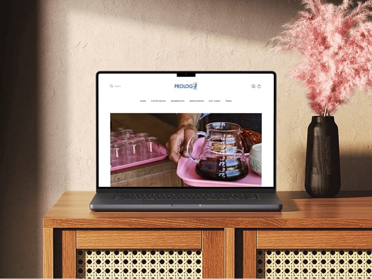 Prolog — laptop mockup with homepage hero on screen