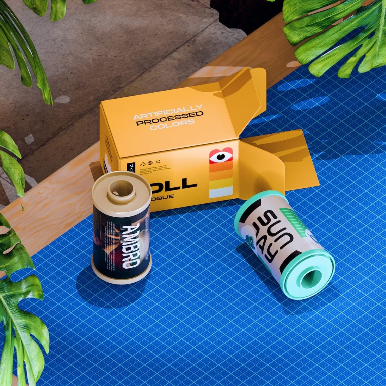 Roll packaging and film-style canisters on a bright blue cutting mat with monstera leaves and sharp sunlight