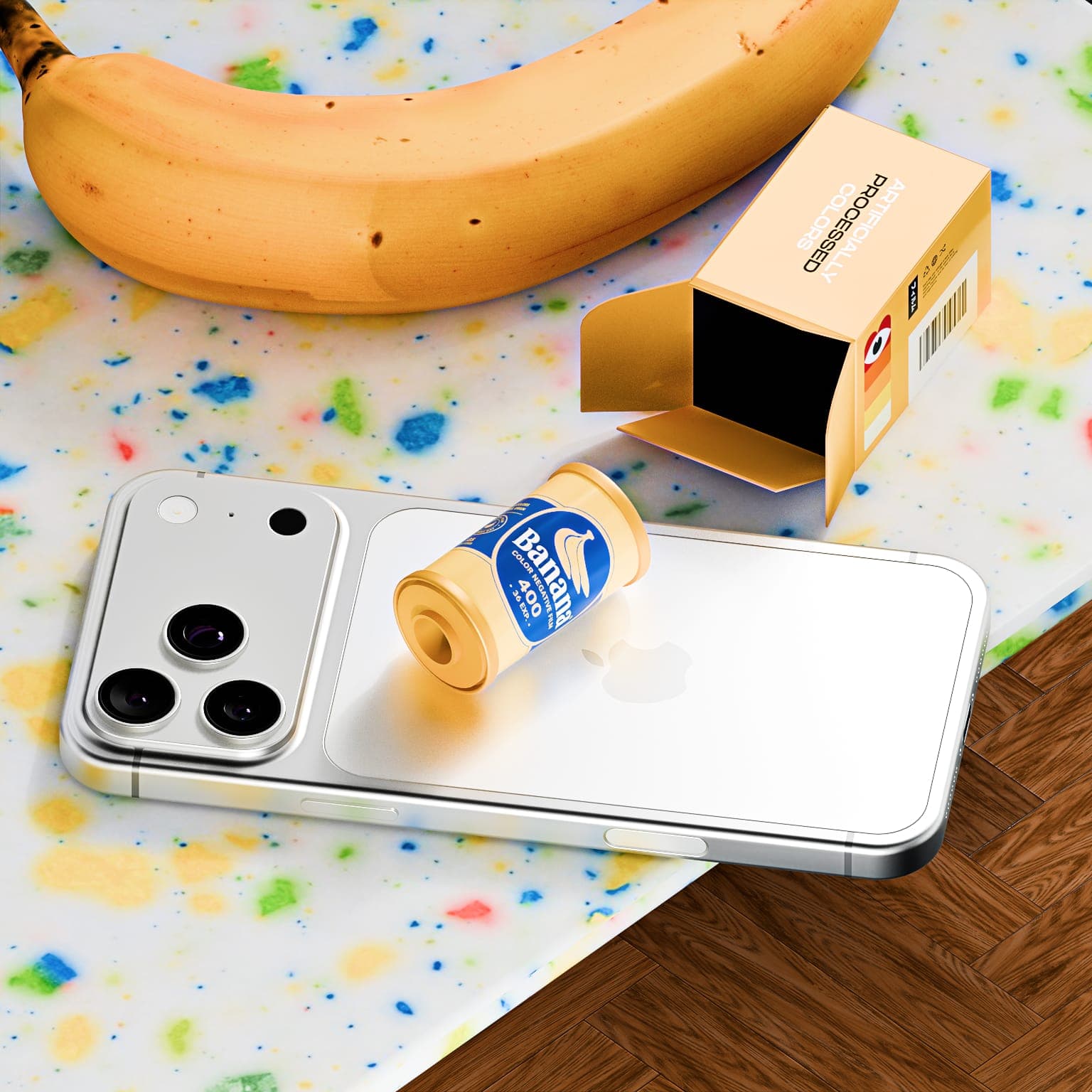 A Banana film canister sitting on the back of a phone, with its open yellow box and a banana on a terrazzo surface.